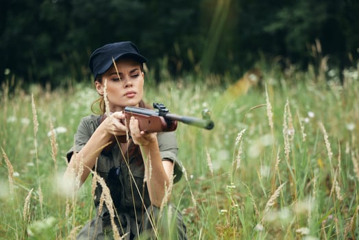 Woman on outdoor weapon in the hands of the green jumpsuit of the shelter photo