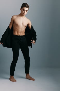 A full-length man with an athletic build and trousers on a gray background photo