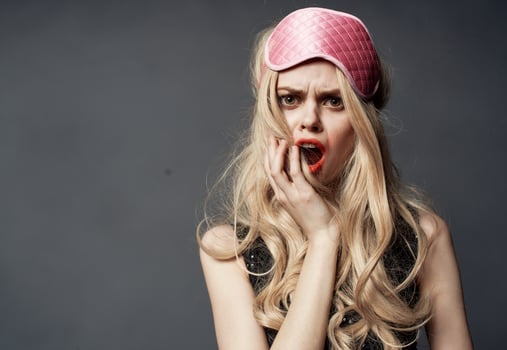 Blonde woman with pink mask for sleep alcoholism health problems model photo