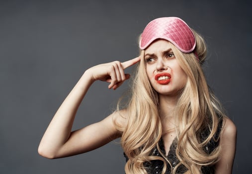 Blonde woman with pink mask for sleep alcoholism health problems model photo