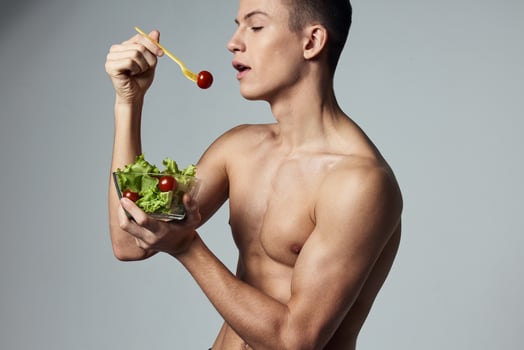 sports guy with a naked torso healthy eating vegetable salad energy workout photo