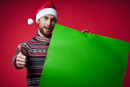 handsome man in a christmas hat with green mockup red background photo
