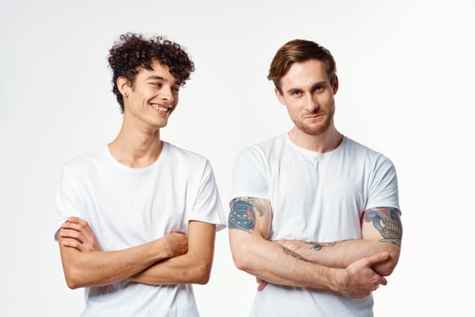 two men in white t-shirts stand side by side cropped view studio friendship photo