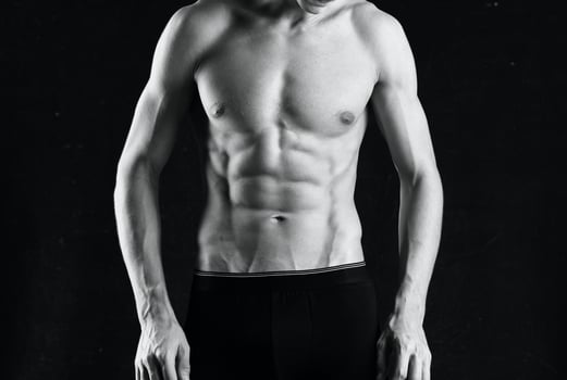 man in white panties such black body fitness posing dark background photo