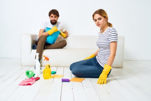 Woman washes the floors A man sits on the couch at home interior cleaning photo