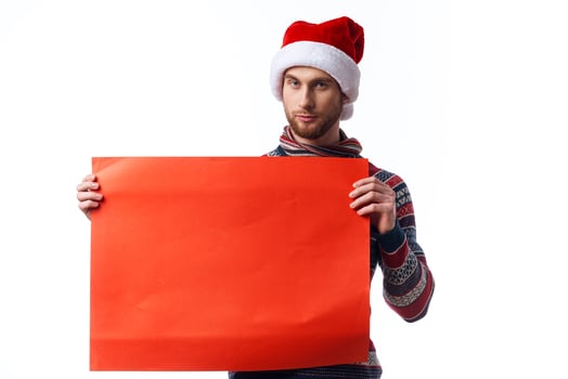 Cheerful man in New Year's clothes holding a banner holiday copy-space studio photo