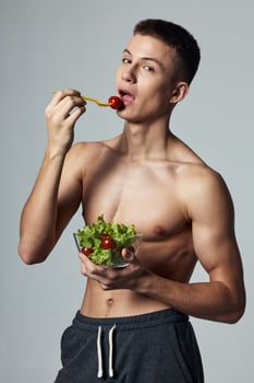 athletic guy with muscular torso eating salad health food diet photo