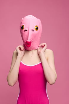 Very strange woman in a pink silicone fish mask for Halloween, crazy image in pink clothes photo