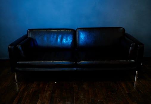 Leather sofa in a dark room, front view and incident light photo