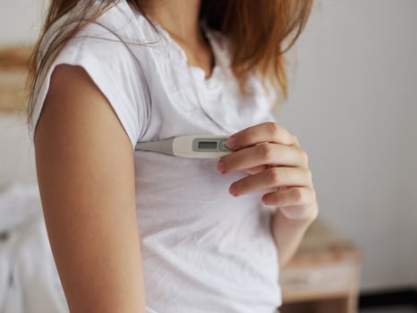 woman with armpit thermometer checking temperature cropped view photo