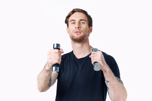 sports man is engaged in fitness on a white background with dumbbells in his hands photo