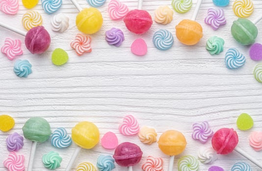 Sweet lollipops and candies on white wooden background photo