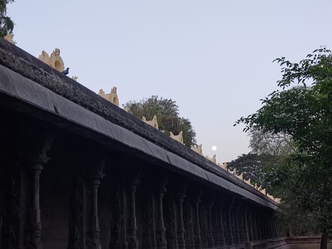 The moon rises over the temple at sunset photo