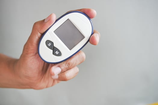 man's hand measuring blood sugar level photo