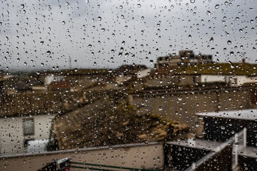 background glass pane in drops of water with a view of the spanish stone photo