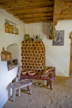 historic farmhouse interior in a museum with an old tiled stove in the corner photo