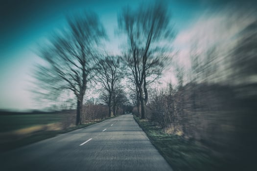 old narrow asphalt road with trees on the side of the road during a car ride in early spring photo