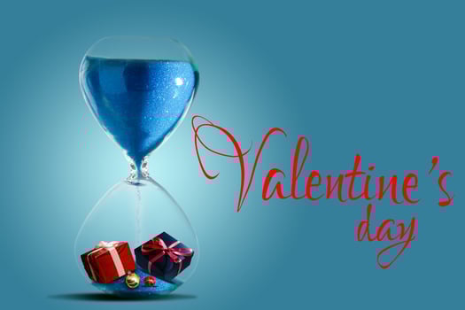 Hourglass as love concept for valentines day on dark gray background. The sand is running out. With copy space. photo