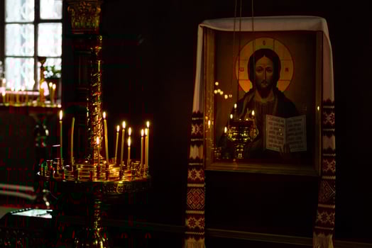 Church candles burn in a candlestick against the backdrop of icons photo