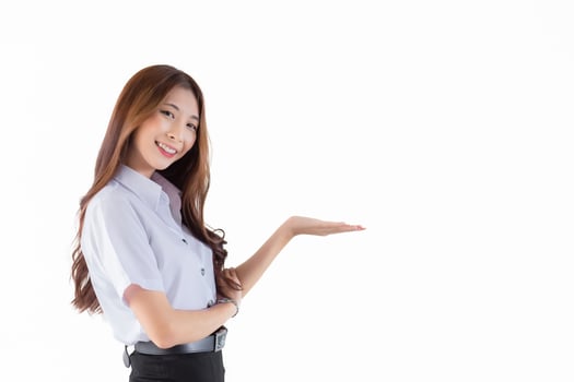 Portrait of an adult Thai student in university student uniform. Young Asian beautiful girl standing to present something confidently on white background. photo