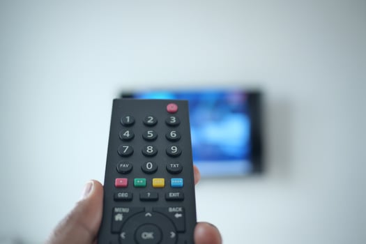 pov shot of man hand holding tv remote. photo