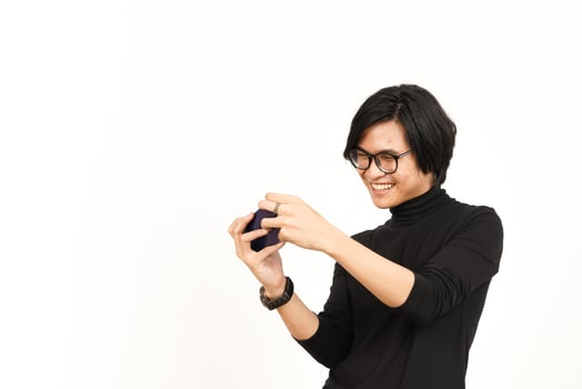 Playing Mobile Game on Smartphone Of Handsome Asian Man Isolated On White Background photo