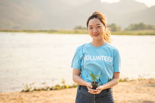 Female Volunteer carrying a seedlings to be planted into the soil in the river as save world concept, nature, environment and ecology. photo