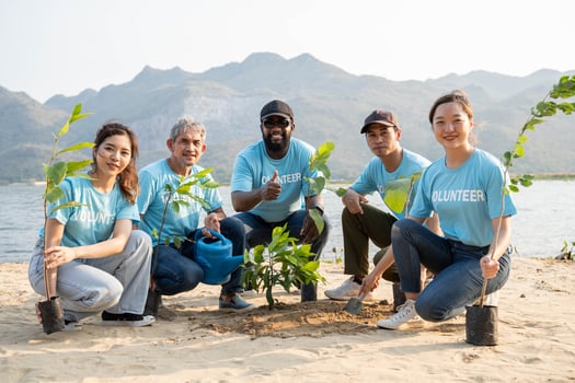 Group of volunteer smiling To Camera sitting On the beach. Protection Of Environment And Nature, Ecology Concept. photo
