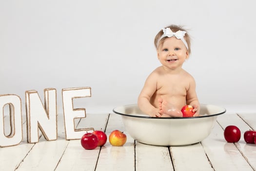 Beautiful baby bathes in a basin. The child is one year old. photo