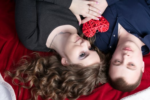 Loving couple from top to bottom. Man and woman with a red heart. Beautiful young husband and wife.Close-up man and woman together.Valentine's day. photo