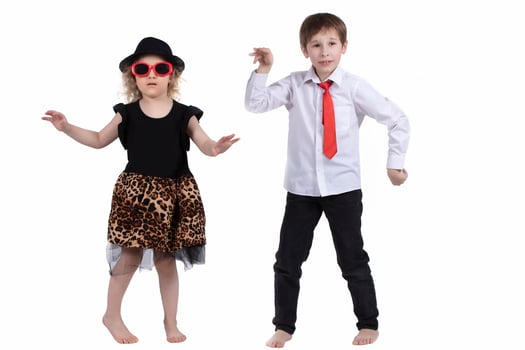 Funny kids dancing on a white background. Little girl in a hat and a boy in a tie are dancing. Ballroom dancing. Dance couple photo