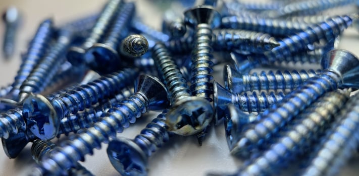 Tapping screws made of steel on Gray background, metal screw, iron screw, chrome screw, screws as a background, wood screw, concept industry. photo