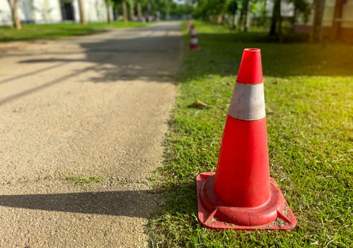 Traffic cones lay on the side of the road. Set up to designate a parking prohibited area along the line because it obstructs the exit. Soft and selective focus. photo