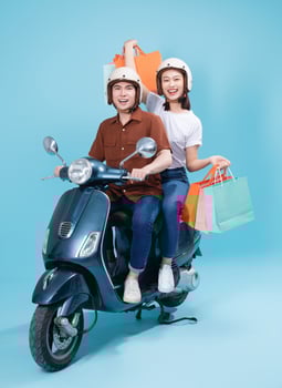 Young Asian couple ride scooter on background photo