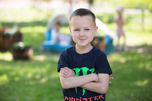 Portrait of a child on a background of a summer street. Seven-year-old boy. photo