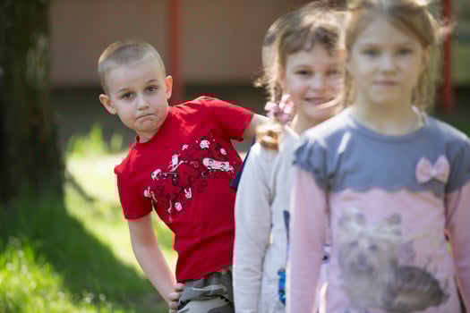 A boy from kindergarten on a summer walk on the background of blurry children photo