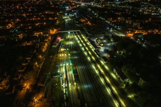 night aerial view over long railway freight trains with lots of wagons stand on parking photo