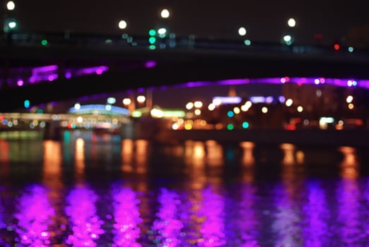 Blurred night cityscape with multi-colored lights and river bridges of Moscow. photo