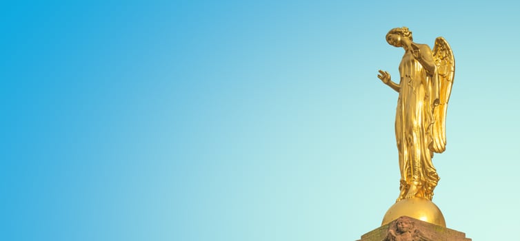 Banner with a beautiful golden angel column statue at Market Square in small town Mittweida, its historical downtown, Saxony, Germany, at blue sunset sky solid background with copy space. photo