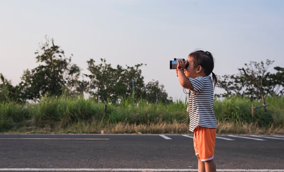 Cute girl looking through binoculars, concept of hiking, camping and adventure. photo
