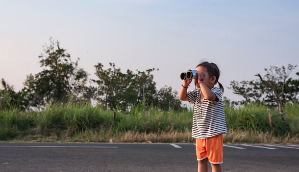 Cute girl looking through binoculars, concept of hiking, camping and adventure. photo