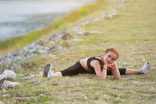 Young girl doing yoga fitness exercise Morning sunrise outdoor in  the meadow beautiful mountains landscape. Meditation and Relax. photo