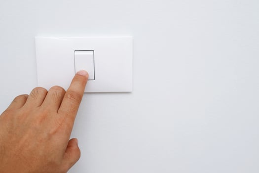 Turn off the light, close up finger man hand is closing the power switch with wall at home  to save energy. reduce global warming. photo