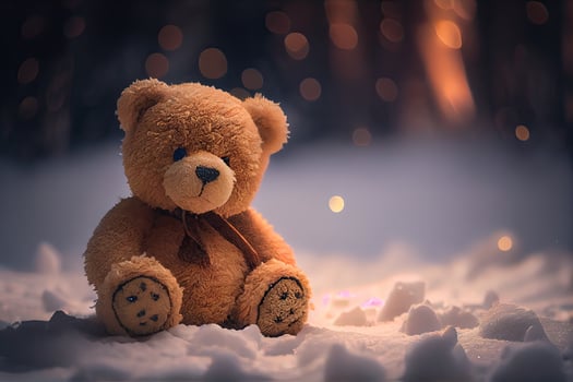 The toy bear was left in the winter at the children's playground. A cute brown bear sitting alone on the snow during winter time. photo