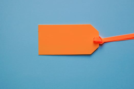 orange price tag on the blue background photo