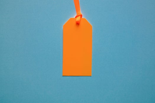orange price tag on the blue background photo