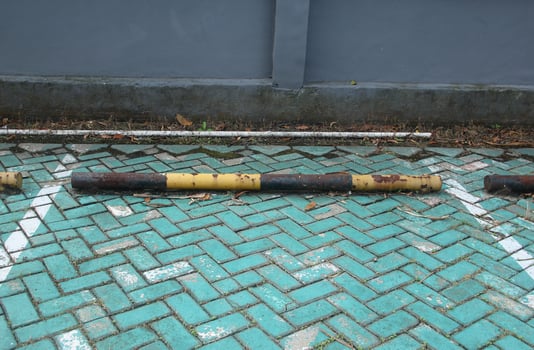 Black and yellow colored parking fence object outdoor isolated on green and white brick flooring isolated on landscape background. photo