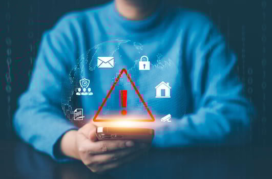Man using smartphone with triangle caution warning sign for notification error, Programmer using laptop with triangle caution warning sign, hacker attacks and hacking data, cyber crime, cyber security photo