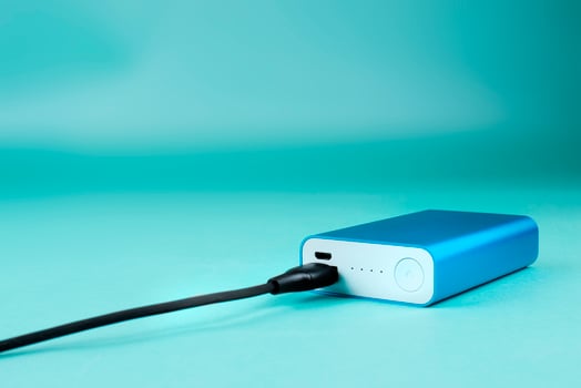 blue power bank with black cable on blue background photo