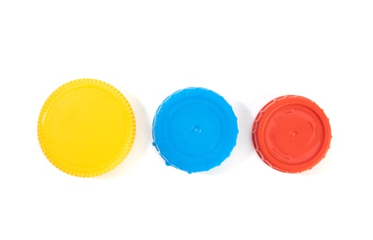 Yellow blue and red plastic screw caps isolated on white background photo